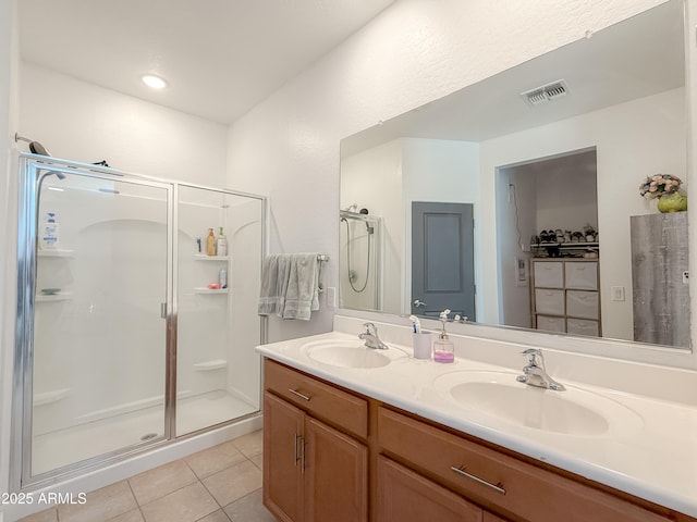 bathroom featuring tile patterned flooring, vanity, and walk in shower