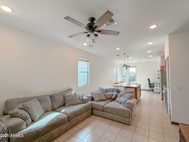 tiled living room featuring ceiling fan and sink