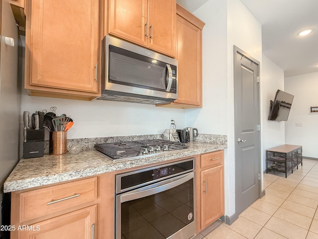 kitchen with light tile patterned flooring and appliances with stainless steel finishes