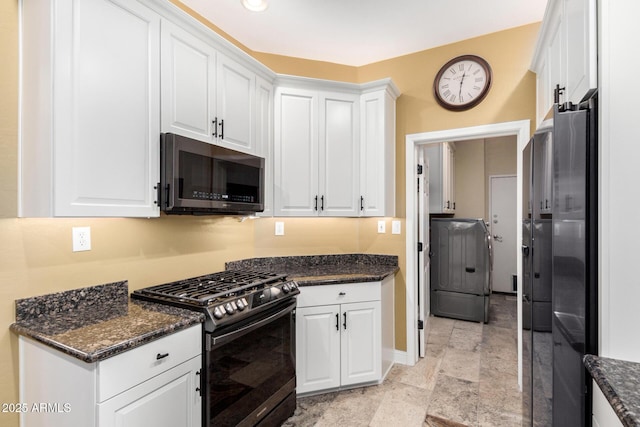 kitchen featuring dark stone counters, white cabinets, and stainless steel appliances