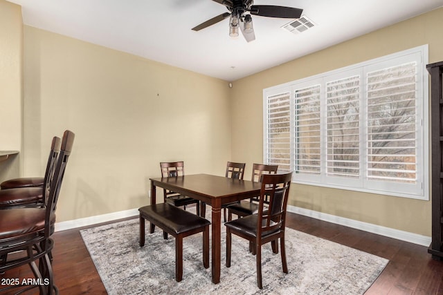 dining room with ceiling fan, visible vents, baseboards, and wood finished floors