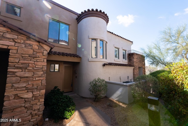 back of property featuring stucco siding and a tile roof