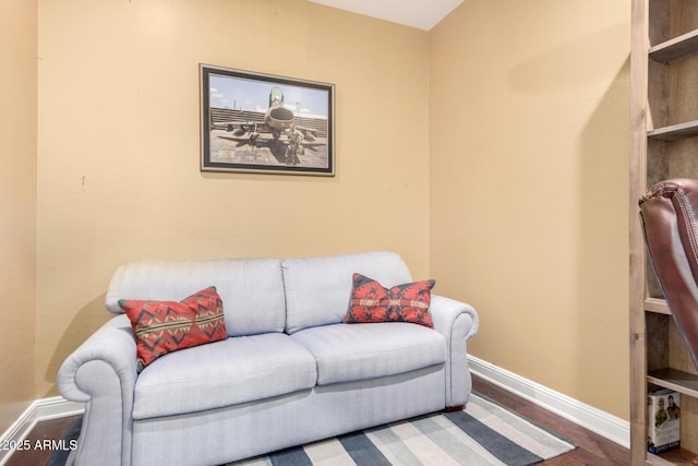 living area with baseboards and wood finished floors