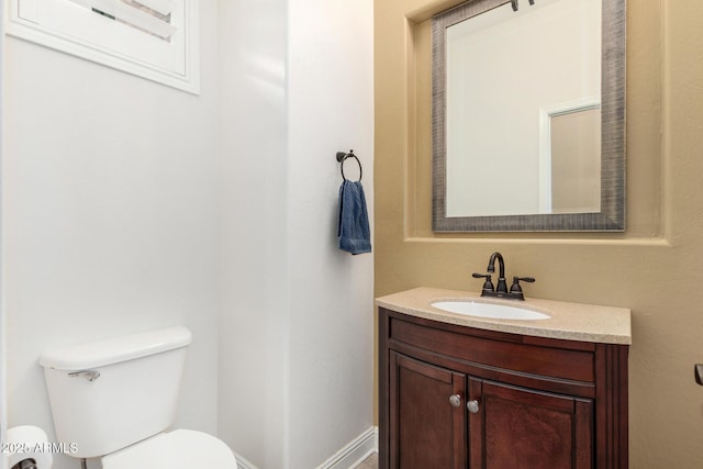 bathroom featuring vanity, toilet, and baseboards