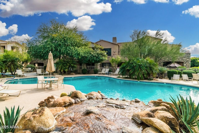 pool with a patio and fence