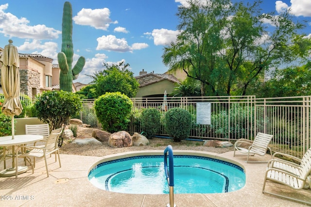 view of pool with a patio, fence, and a hot tub