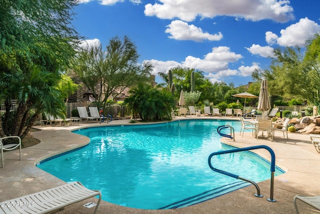 community pool featuring a patio and fence