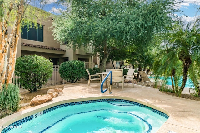 view of swimming pool with a patio and fence