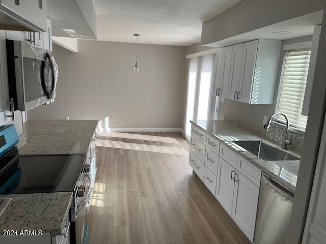 kitchen with white cabinets, pendant lighting, appliances with stainless steel finishes, and sink