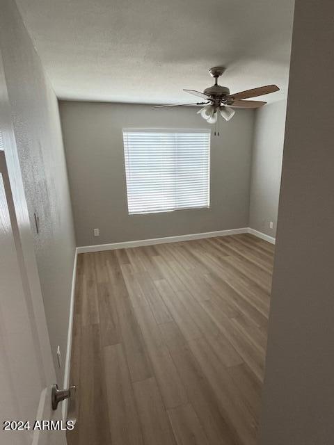 empty room featuring hardwood / wood-style floors and ceiling fan