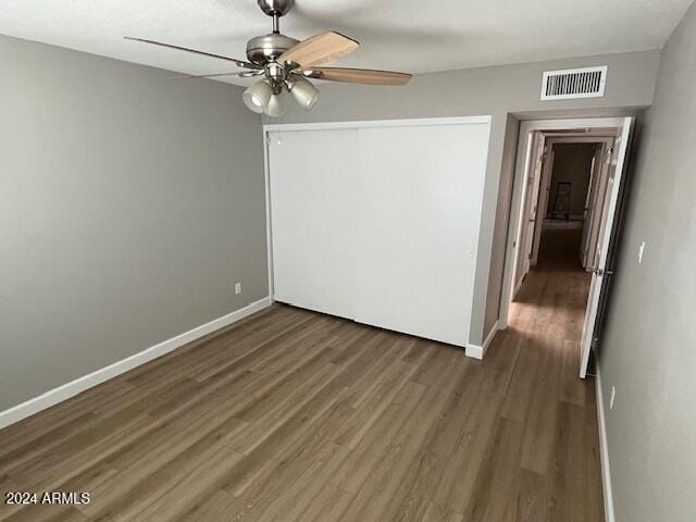 spare room featuring ceiling fan and dark wood-type flooring