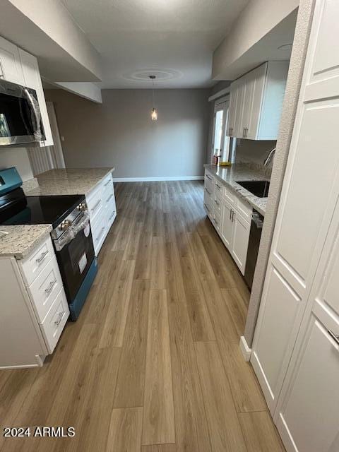 kitchen featuring light hardwood / wood-style floors, white cabinetry, sink, and appliances with stainless steel finishes