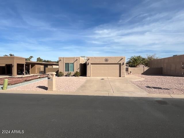 pueblo-style house featuring a garage