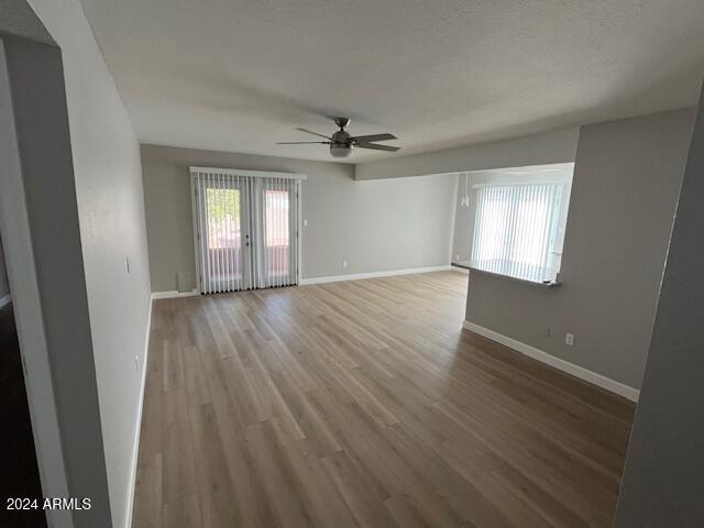 empty room featuring french doors, a textured ceiling, ceiling fan, and hardwood / wood-style floors