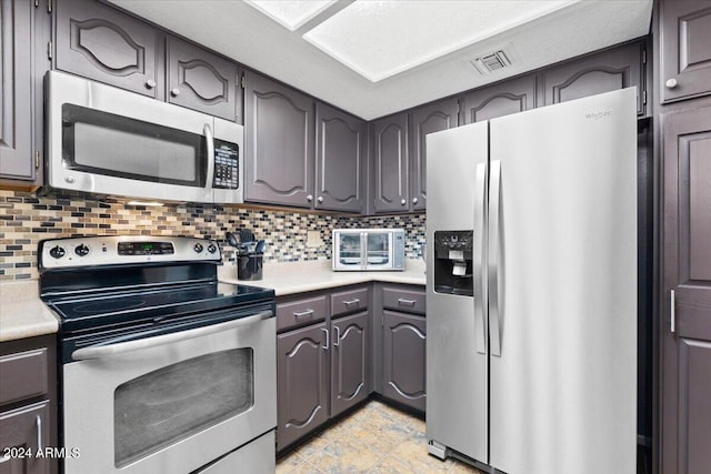 kitchen featuring stainless steel appliances and tasteful backsplash