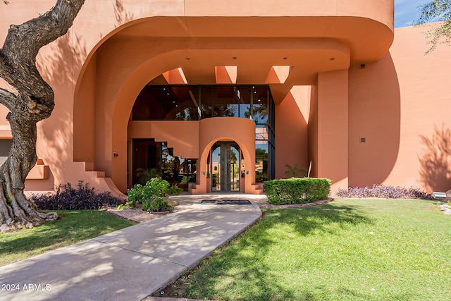 entrance to property with french doors and a yard