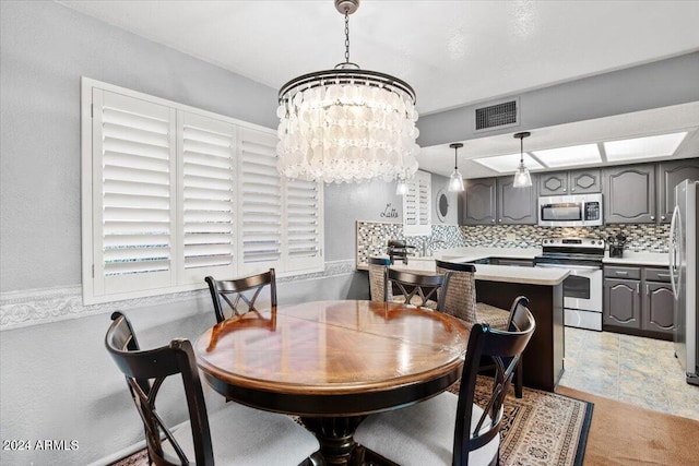 dining space with light tile patterned flooring and an inviting chandelier