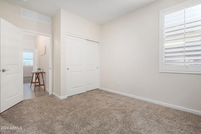 unfurnished bedroom with carpet floors and a closet