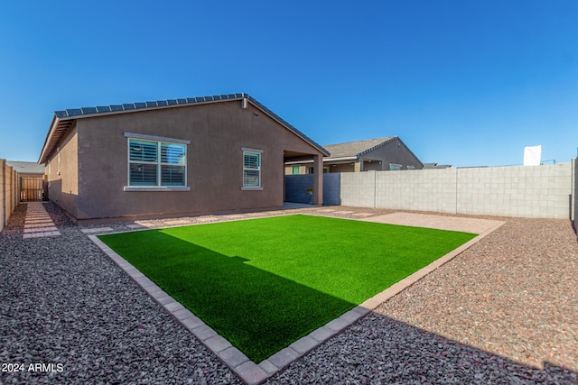 rear view of house with a patio and a yard