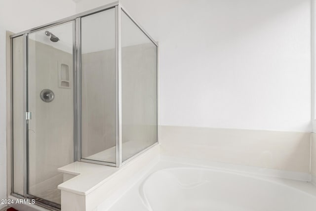 bathroom featuring shower with separate bathtub