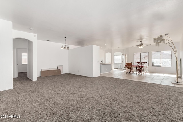 unfurnished living room with a healthy amount of sunlight, ceiling fan, and light colored carpet