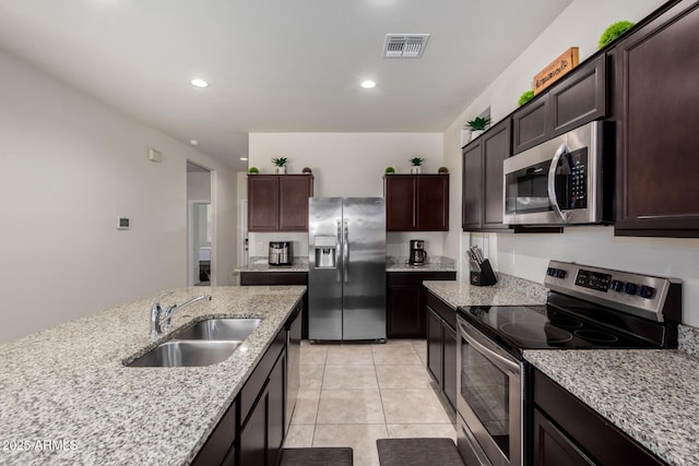 36454 W Picasso St, Maricopa, AZ 85138 - kitchen featuring stainless steel appliances, a sink, dark brown cabinets, light stone counters, and recessed lighting