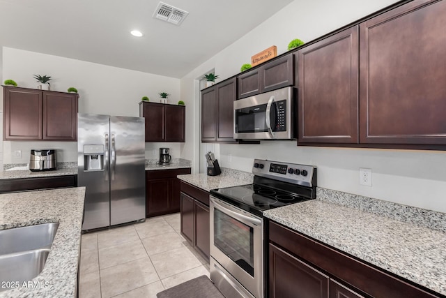 36454 W Picasso St, Maricopa, AZ 85138 - kitchen with appliances with stainless steel finishes, light tile patterned floors, dark brown cabinets, a sink, and recessed lighting