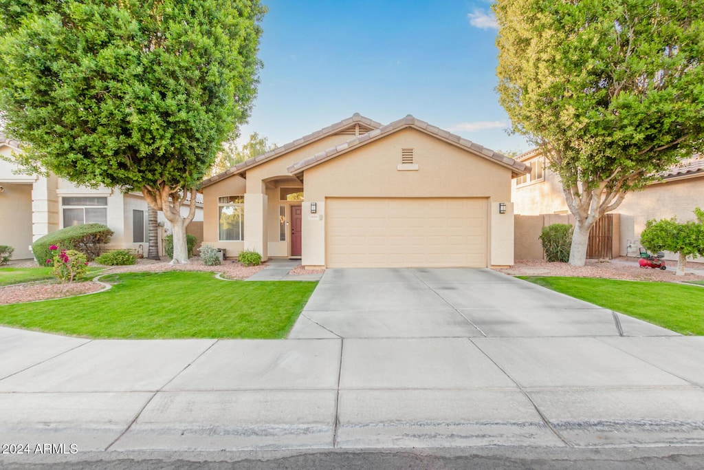 view of front of property with a front yard and a garage