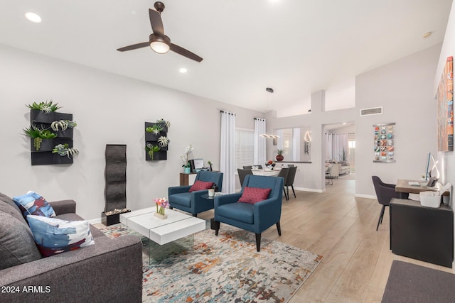 living room featuring ceiling fan, lofted ceiling, and light wood-type flooring