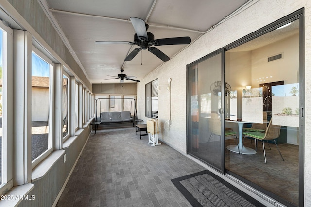 unfurnished sunroom featuring ceiling fan