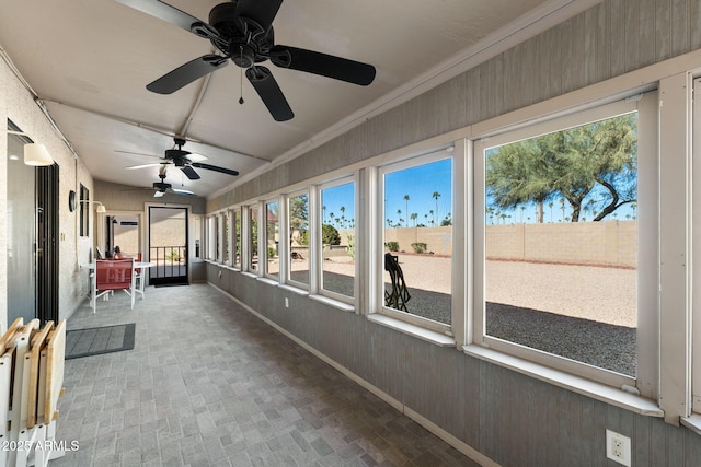 unfurnished sunroom with ceiling fan and a healthy amount of sunlight