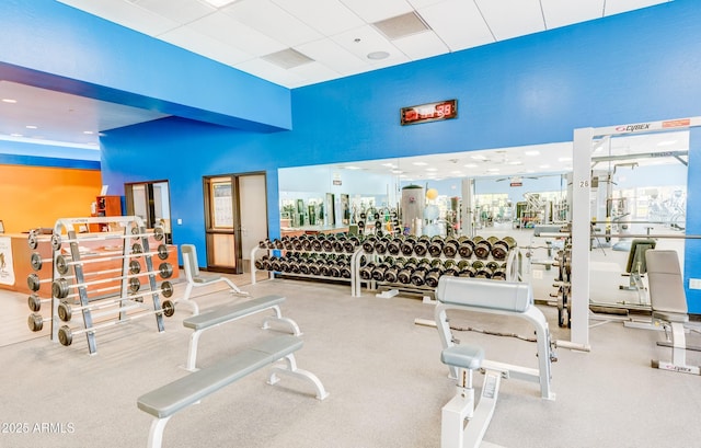 workout area with a towering ceiling and a drop ceiling