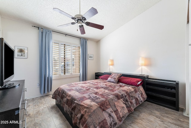 bedroom with a textured ceiling, ceiling fan, and lofted ceiling