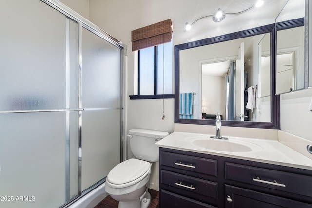 bathroom with vanity, a shower with shower door, and toilet