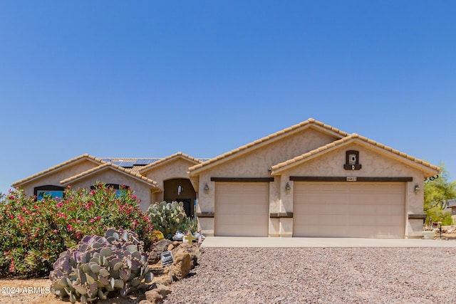 view of front of home featuring solar panels and a garage