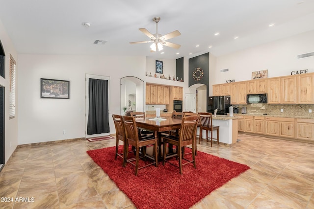 dining area with ceiling fan and high vaulted ceiling