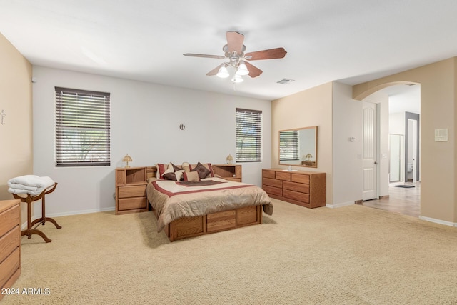 bedroom with light carpet, multiple windows, and ceiling fan