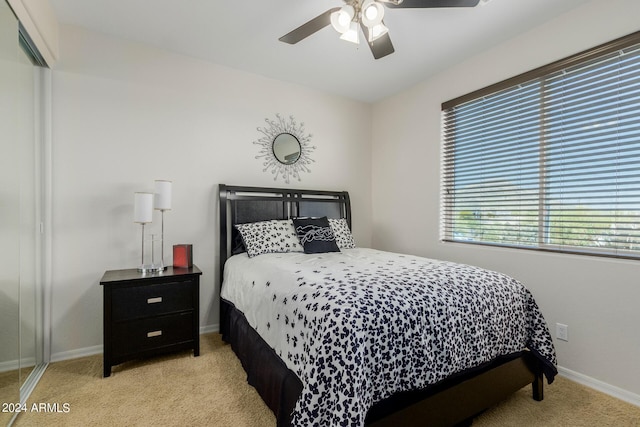 bedroom with ceiling fan, a closet, and light colored carpet