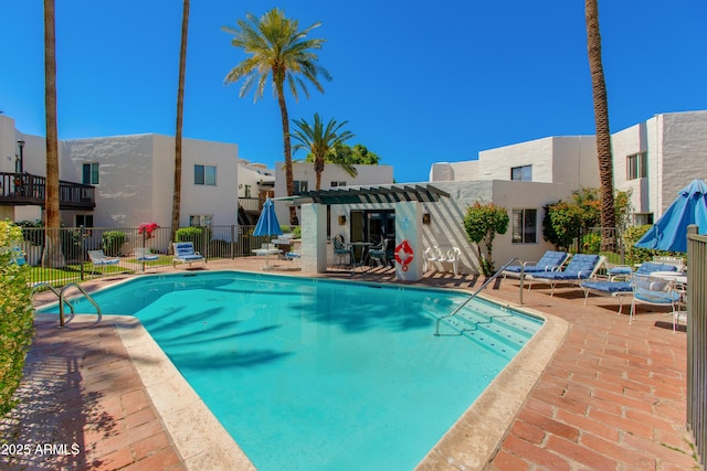 community pool with a pergola, fence, and a patio