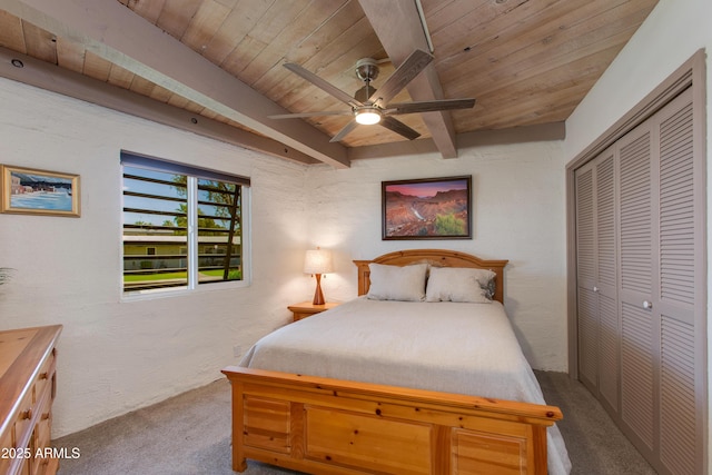 bedroom with carpet floors, beam ceiling, wood ceiling, a closet, and ceiling fan