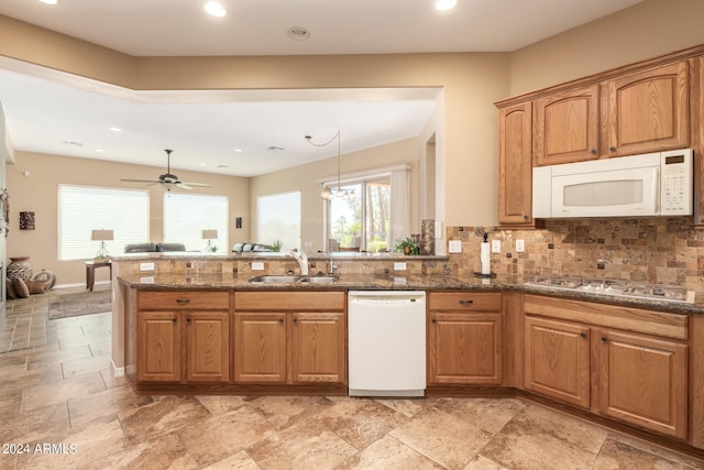 kitchen featuring tasteful backsplash, sink, white appliances, decorative light fixtures, and ceiling fan