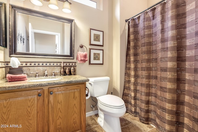 bathroom with a shower with shower curtain, vanity, and toilet