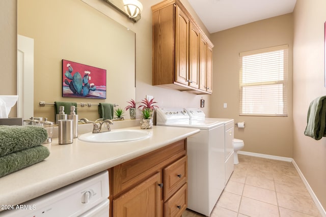 washroom with light tile patterned floors, sink, and washing machine and dryer