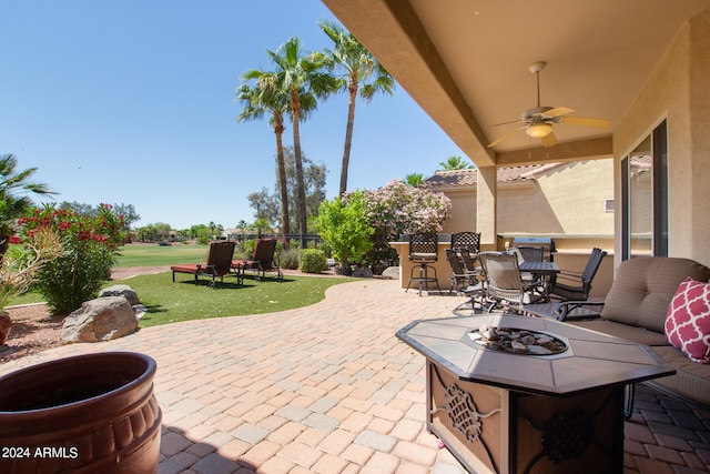 view of patio / terrace with ceiling fan and a fire pit