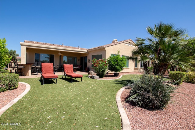 rear view of house featuring a yard and a patio