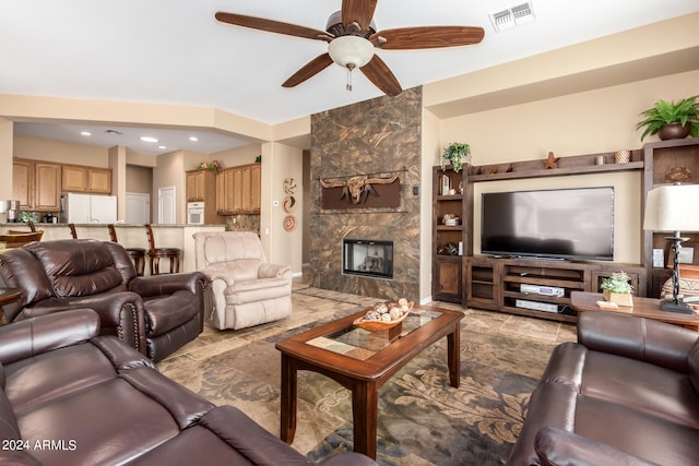 living room featuring a fireplace, ceiling fan, and built in shelves