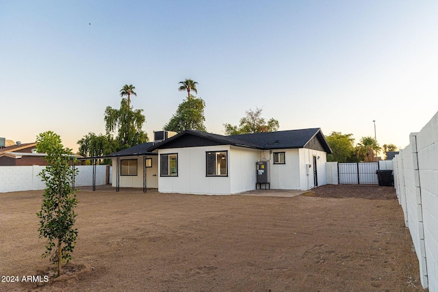 back house at dusk featuring cooling unit