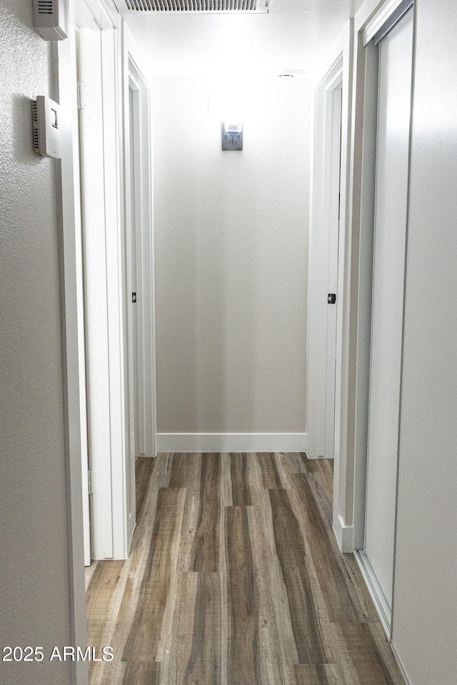 corridor with dark hardwood / wood-style flooring