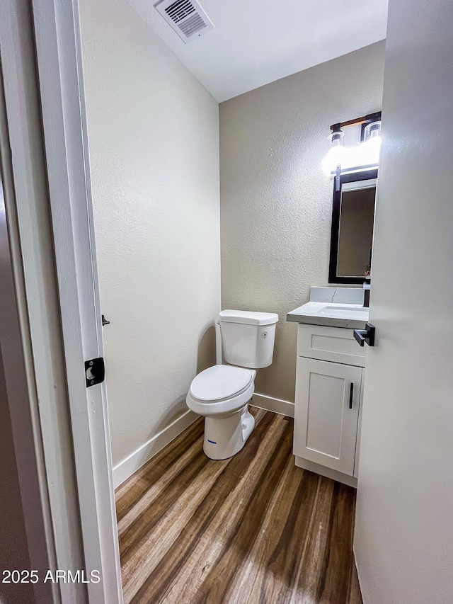 bathroom with vanity, wood-type flooring, and toilet