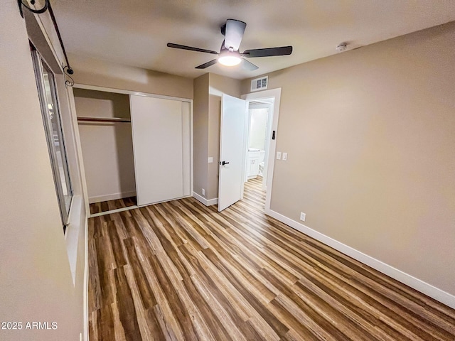 unfurnished bedroom with hardwood / wood-style floors, ceiling fan, and a closet